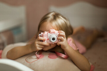 little girl taking pictures with her pink camera