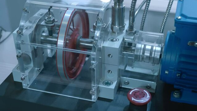 Blue powerful electric motor rotates the shaft on which the pulley spins. Shot in motion