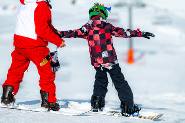 Boy Learning Snowboarding with an Instructor