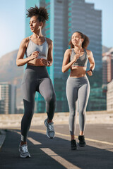 Women, fitness and running on city street or road in workout, training or exercise for cardio health, marathon or wellness. People, friends and runner athletes in sports warmup with motivation goals