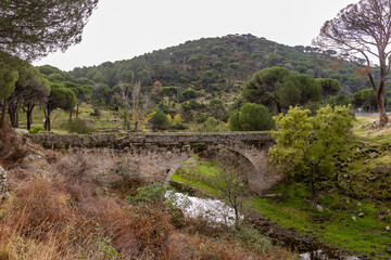 Fototapeta na wymiar Bridge over the Becedas River in El Hoyo de Pinares. Avila, Spain