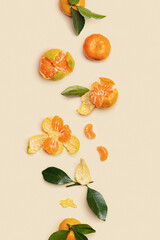 Orange yellow juicy tangerines with green leaves, whole and peeled on neutral beige vertical...