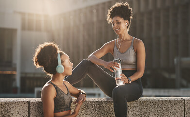 Headphones, fitness and black woman friends in city with water bottle, training gear and music for...