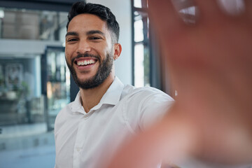 Obraz premium Selfie, happy and success with a business man taking a picture while standing alone in the office at work. Portrait, confidence and smile with a male employee posing for a photograph while working