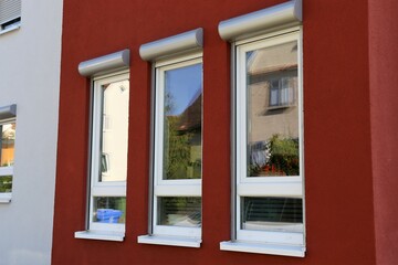 Neue Fenster mit Vorbaurollladen an einem renovierten Altbau mit neu gestrichener Fassade