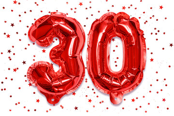 The number of the balloon made of red foil, the number thirty on a white background with sequins....