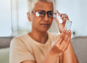 Glasses, medicine and pills senior woman reading information for healthcare, insurance and wellness at home. Elderly or old woman check label bottle or container for medical pharmaceutical medication