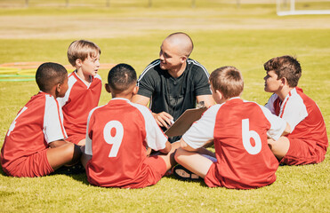 Obraz premium kids, soccer and team coach planning training with clipboard on soccer field for sport competitiion together. Athlete children, teamwork and sit on grass before football match or workout outdoors