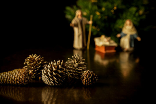 Still life of pine cones with Christmas belen and tree on background