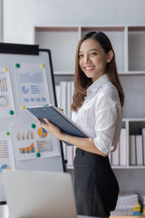 Young business Asian woman holding document file and stand in home office