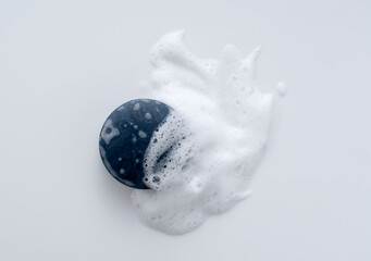 Solid soap with foam placed on white background.