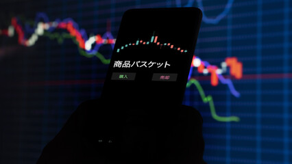 投資家が携帯電話で 商品バスケット ETF を分析している 商品バスケット .
