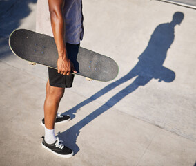 Skateboarding, sport and man holding a board for fun, riding and playing at a park. Legs, shadow...