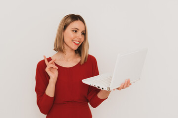 stylish European woman in red dress using laptop for communication isolated on white background