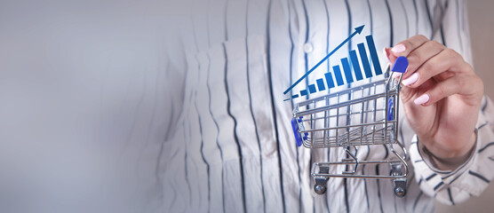 Woman showing Shopping cart and growth graph. Increase in sales