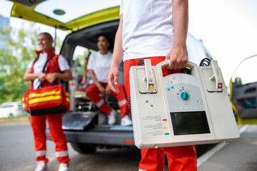 Hand of the doctor with defibrillator. Teams of the Emergency medical service are responding to an...