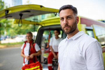 Paramedic nurse and emergency doctor at ambulance with kit. a paramedic, standing at the rear of an ambulance, by the open doors.