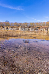 Old abandoned quarry with water at the rock face