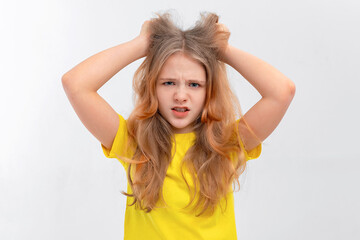 Fototapeta premium Panicking freaked out teen girl wearing casual yellow tshirt screaming shocked and scared holding hands on head popping eyes at camera frightened, being tensed and acting crazy, white background
