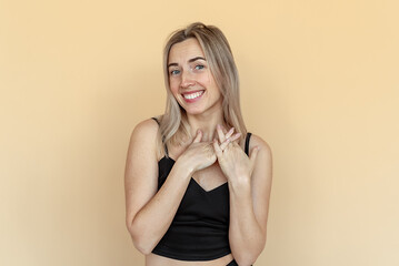 Studio portrait of happy young woman smiling looks embarrassed, smiling feels very confused. Shy...