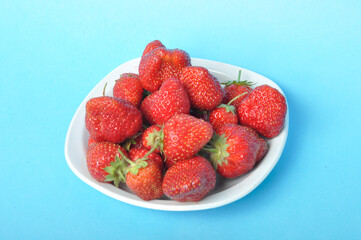 Strawberries on a plate on a blue background