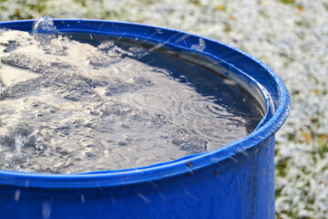 Freezing water in a plastic barrel in winter in the garden