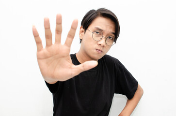 Ew. It's so gross. A young Asian man displaying an expression of dislike and disgust while covering...