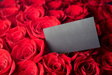 A blank black card with space for text in the bouquet of red roses