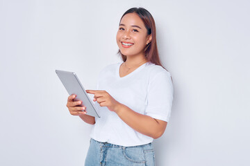 Portrait of smiling young Asian girl in white t-shirt using digital tablet isolated on white background