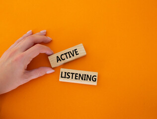 Active listening symbol. Wooden blocks with words Active listening. Businessman hand. Beautiful...
