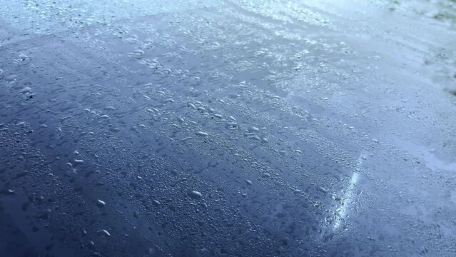 Drops of water on the windshield of a car. Melted frost in the morning on the car.