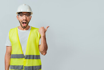 Surprised face construction worker pointing at an advertisement. Engineer man pointing to side. Surprised face engineer pointing finger to the right, Surprised engineer pointing to the side