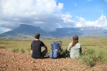 Fototapeta na wymiar Casal não identificado, de costas, sentado em frente ao Monte Roraima, Venezuela, no primeiro dia de trekking 
