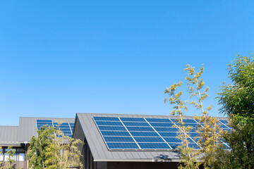 太陽光パネルが設置された住宅の屋根と快晴の青空。
環境のコンセプト。