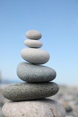 Fototapeta na wymiar Stack of stones on beach against blurred background, closeup