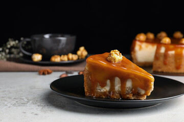 Piece of delicious cake with caramel and popcorn on light grey table, space for text - obrazy, fototapety, plakaty