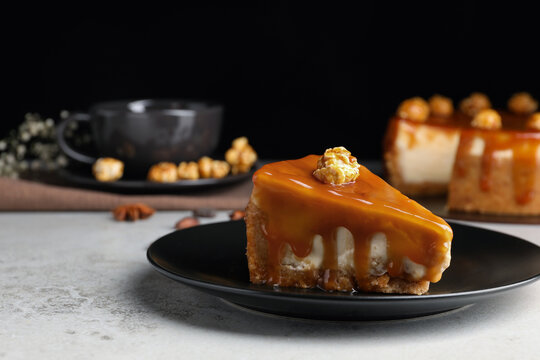 Piece of delicious cake with caramel and popcorn on light grey table, space for text