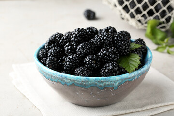 Tasty ripe blackberries in bowl on table