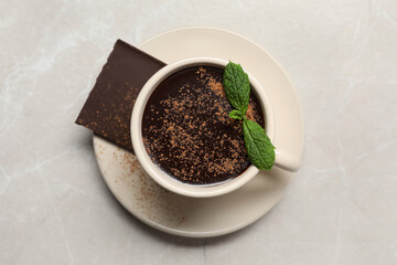 Cup of delicious hot chocolate with fresh mint on grey table, top view