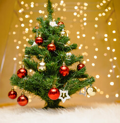 A Christmas or New Year tree decorated with Christmas toys on the background of lights of a glowing garland