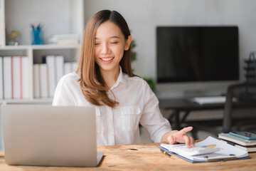 Young asian businesswoman beautiful charming smiling and using on mobile phone in the office.