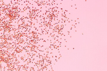 Shiny crystals confetti texture on a pink background. Festive concept with copy space.