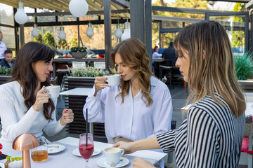 Girlfriends talking in a outside cafe bar