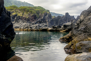 Natural swimming pool between volcanic rocks on Sao Jorge, Azores, Portugal. 