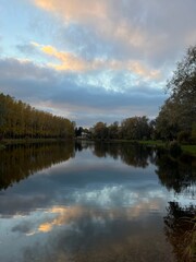 Fototapeta na wymiar Autumn trees reflection on the pond surface in the park