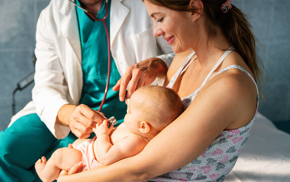 Mother Holding Baby For Pediatrician Doctor To Examine