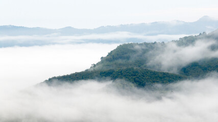 Aerial view of clouds on beautiful mountains that covers the fertile tropical forests South of Thailand.