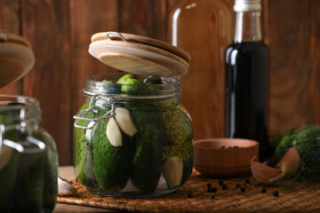 Glass jars with fresh cucumbers ready for canning on wooden table