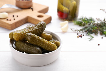 Tasty pickled cucumbers on white wooden table, space for text