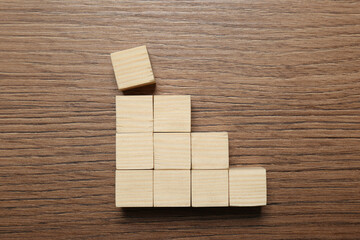 Blank cubes on wooden table, flat lay with space for text. Idea concept